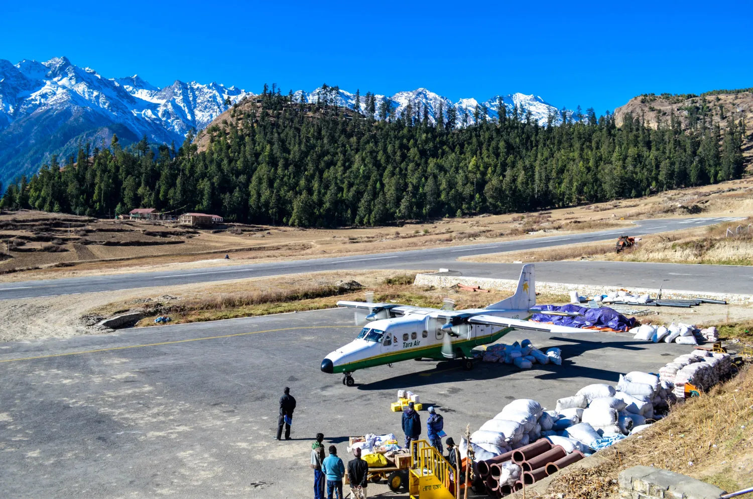 Small airplane on a runway with mountains in the background