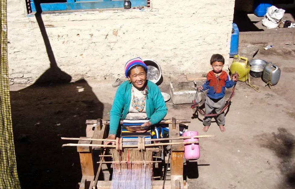 women weaving threads in rural nepal